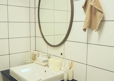 Modern bathroom with white tiles and oval mirror