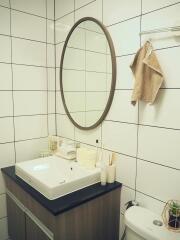 Modern bathroom with white tiles and oval mirror