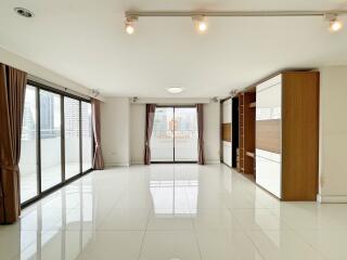 spacious living room with large windows and glossy tile flooring