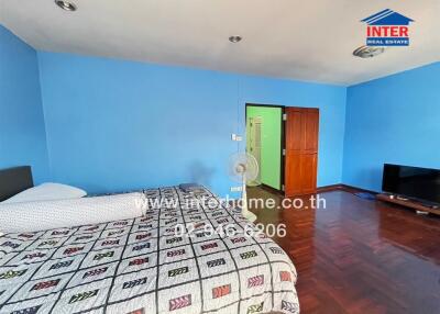 Spacious bedroom with blue walls and wooden flooring