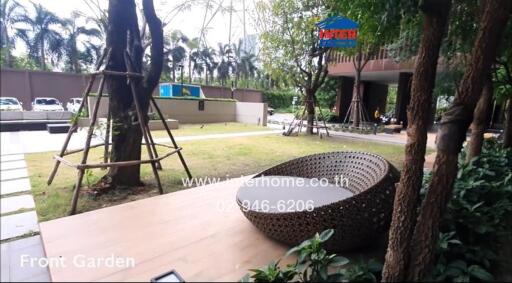 Front garden with a modern wicker seating area and surrounding greenery