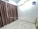 Bedroom with wooden floor and draped windows