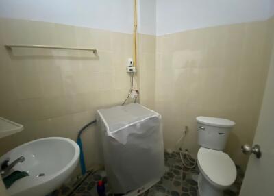 Small bathroom with sink, toilet, and washing machine