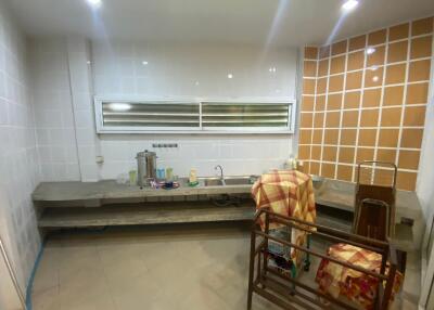 Simple kitchen with open shelves and a tiled wall