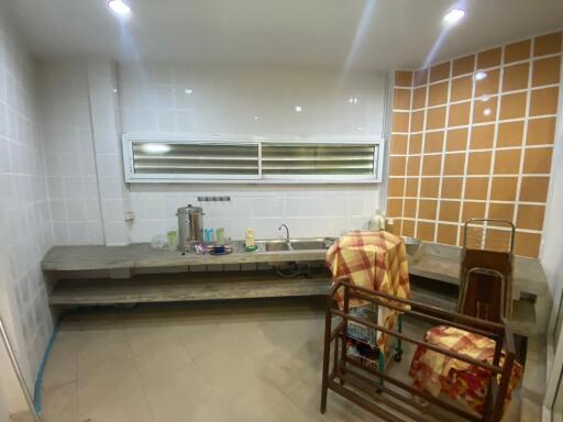 Simple kitchen with open shelves and a tiled wall