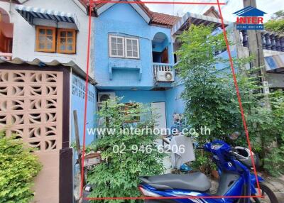 Exterior view of a colorful townhouse with a blue facade