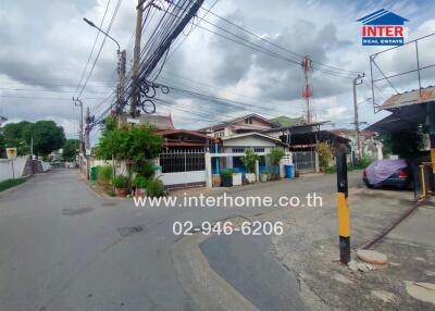 Street view of a residential area with houses and electric poles