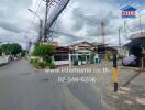 Street view of a residential area with houses and electric poles