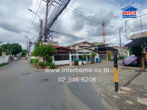 Street view of a residential area with houses and electric poles