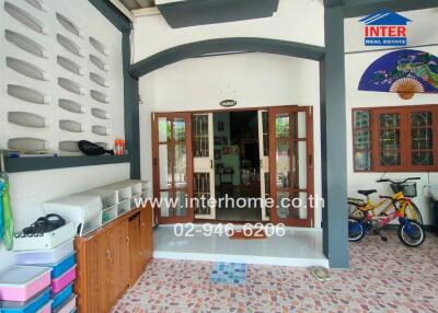 Covered outdoor patio with wooden doors leading inside