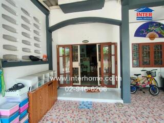 Covered outdoor patio with wooden doors leading inside