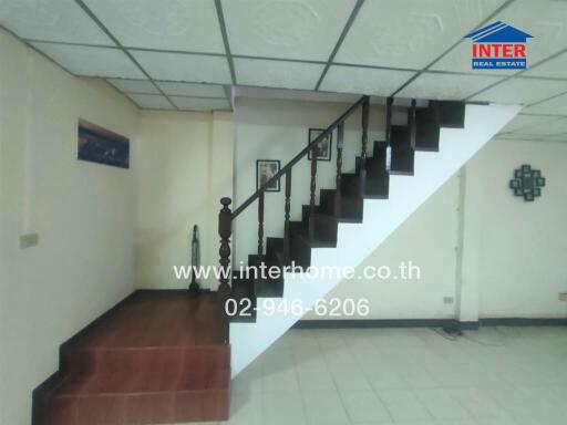 Staircase in a living area with wooden steps and railing