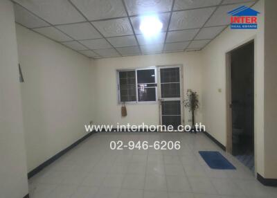 Living room with tiled ceiling and floor, window with bars, and minimal decor