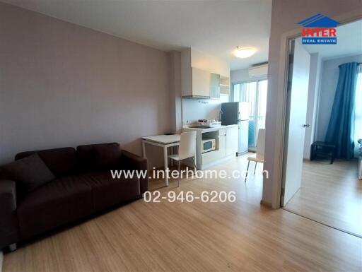 Main living area with open kitchen and visible bedroom