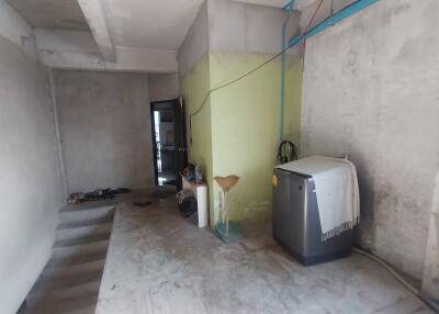 Unfinished room with concrete walls and appliances