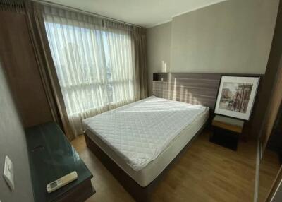 Bedroom with a large window, bed, and nightstand