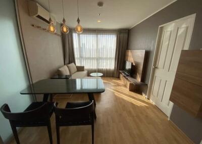 Modern living room with a sofa, dining table, and TV.