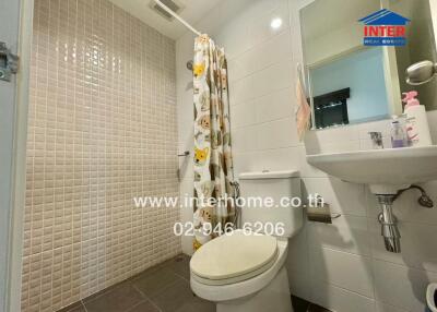 Modern bathroom with shower, sink, and toilet.