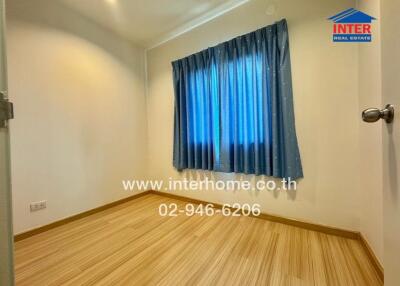 Cozy bedroom with wooden flooring and blue curtains