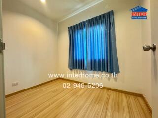 Cozy bedroom with wooden flooring and blue curtains