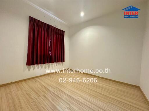 Spacious empty bedroom with red curtains and wooden floor
