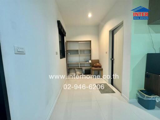 Well-lit hallway with shelving unit and chair