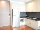 Modern kitchen with stainless steel appliances and wooden flooring