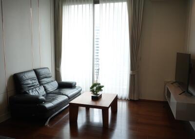 Modern living room with leather sofa, coffee table, and TV