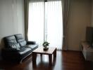 Modern living room with leather sofa, coffee table, and TV