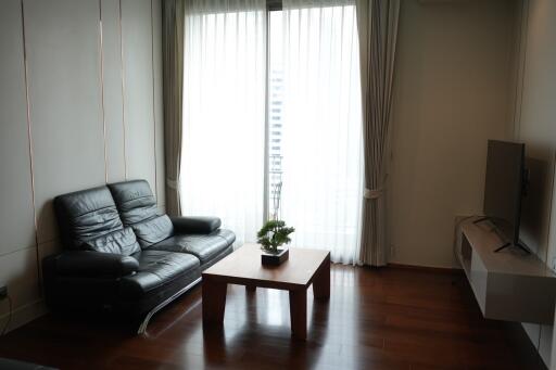 Modern living room with leather sofa, coffee table, and TV