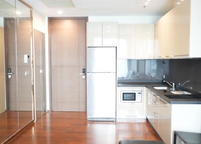 Modern kitchen area with stainless steel appliances and wooden flooring