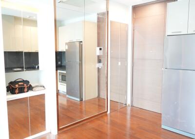 Modern kitchen with wooden flooring and mirrored cabinets