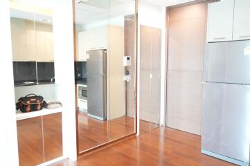 Modern kitchen with wooden flooring and mirrored cabinets