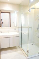 Modern bathroom with a glass-enclosed shower and a large mirror