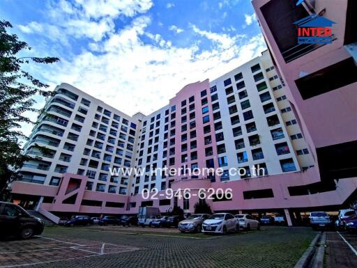 View of a multi-storey apartment building with parking lot