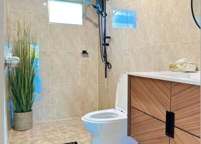 Modern bathroom with toilet, shower, vanity, and decor