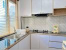 Modern kitchen with white cabinets, gas stove, and subway tile backsplash