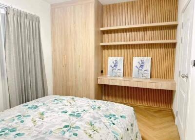 Bedroom with built-in wooden cabinetry and wall decor