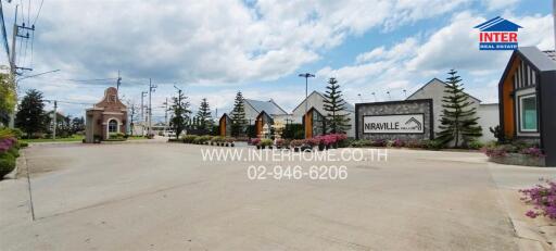 Main entrance of Niraville housing community with signage and gatehouse