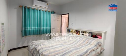 Bedroom with bed, air conditioner, and colorful curtains