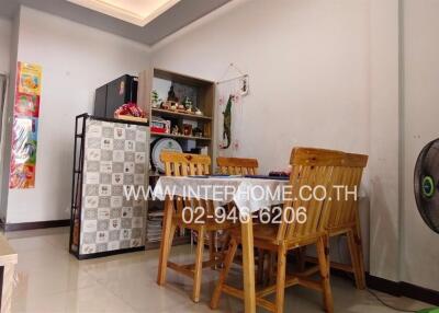 dining area with wooden chairs and table, refrigerator, and a corner shelf