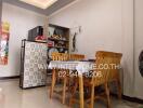 dining area with wooden chairs and table, refrigerator, and a corner shelf