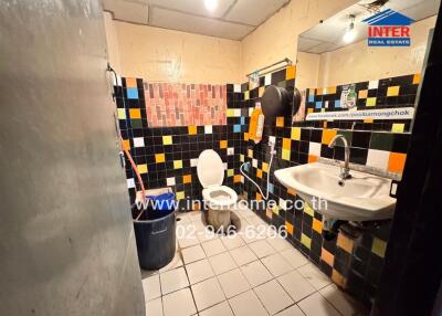 A bathroom with colorful tiled walls, a sink, and a toilet