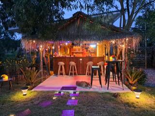 Outdoor bar area with seating, lighting, and a covered roof