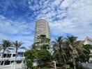 Tall residential building with surrounding palm trees and outdoor seating