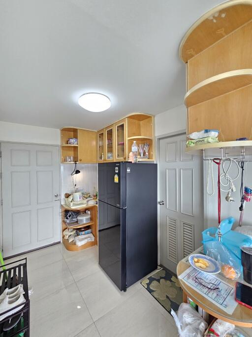 Modern kitchen with black refrigerator and wooden cabinets