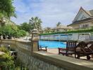 Swimming pool area with seating and surrounding houses