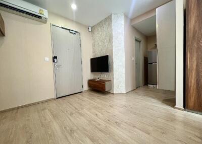 Modern living room with wooden flooring, air conditioning, and mounted TV