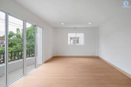 Spacious living room with large windows and wooden flooring