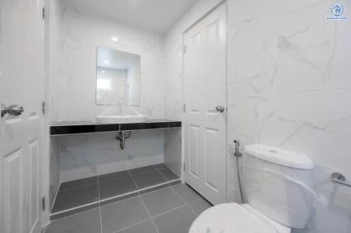 Modern bathroom with large mirror and tiled walls